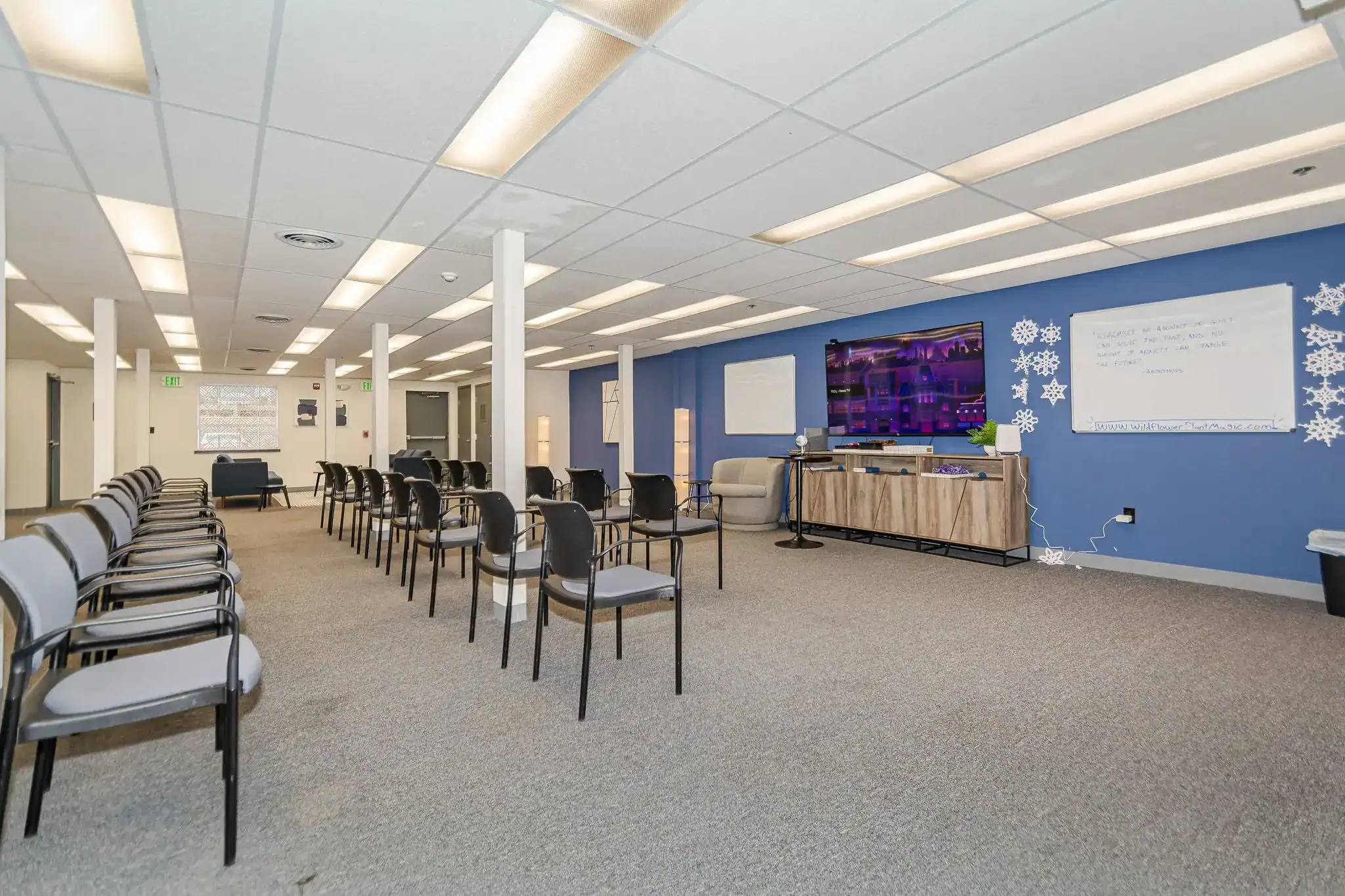 Group meeting room with rows of chairs and TV