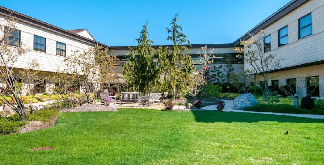 Courtyard with grass, benches, and landscaped trees