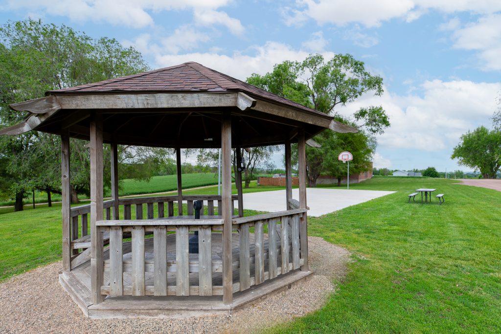 Wooden gazebo beside a basketball court and picnic table