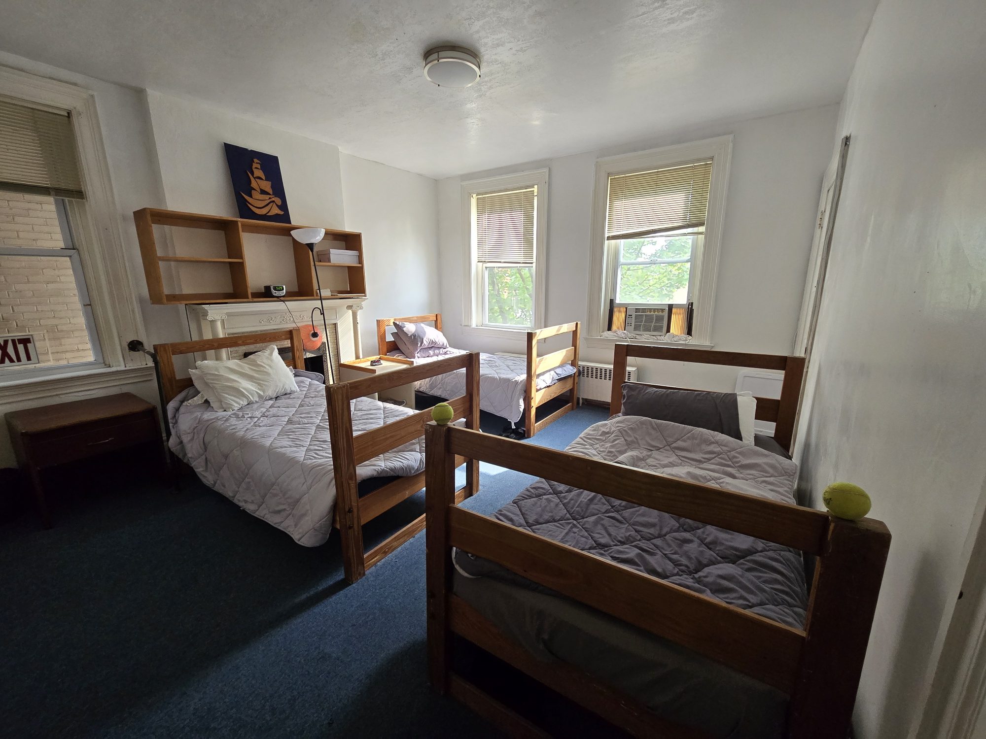 Bedroom with three single beds and two windows.