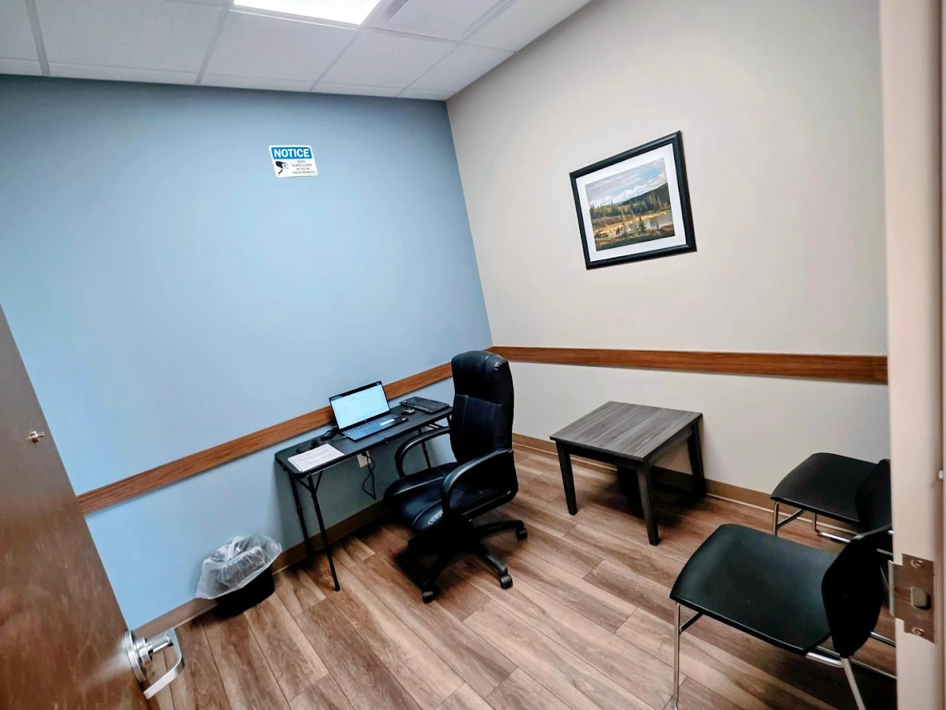 Two service windows in the BrightView Health OTP dispensing area with counters, privacy partitions, computer equipment, and wood-look flooring