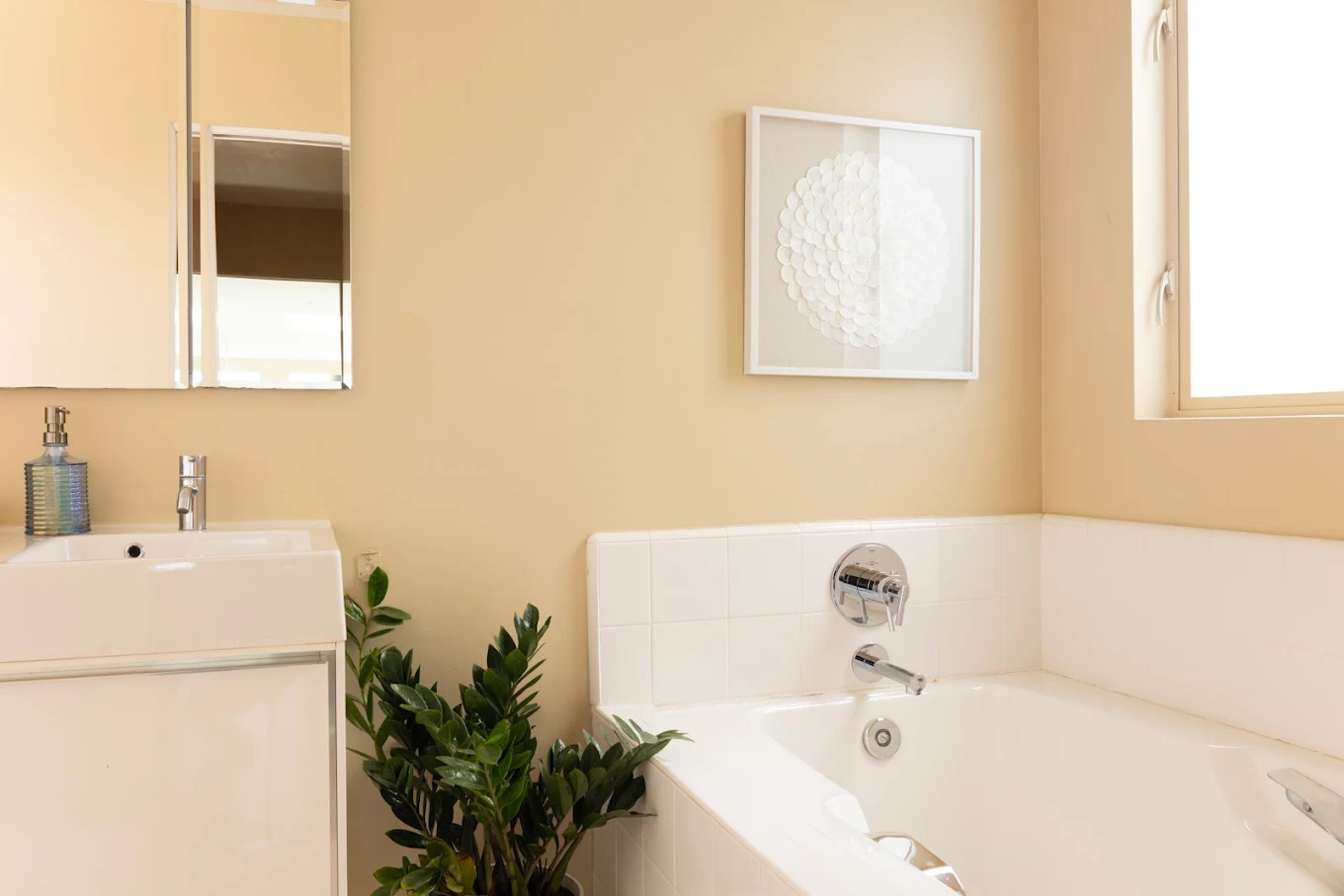 Modern bathroom with bathtub, sink, and indoor plant