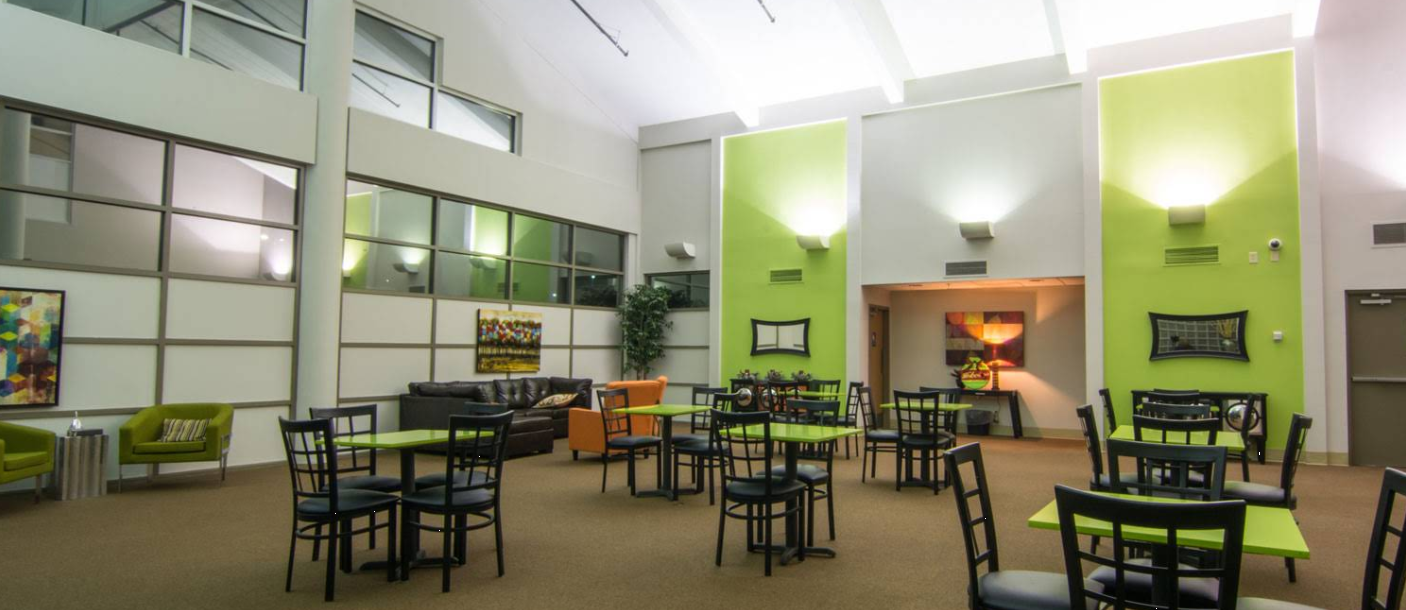 Bright green common area with tables and lounge seating