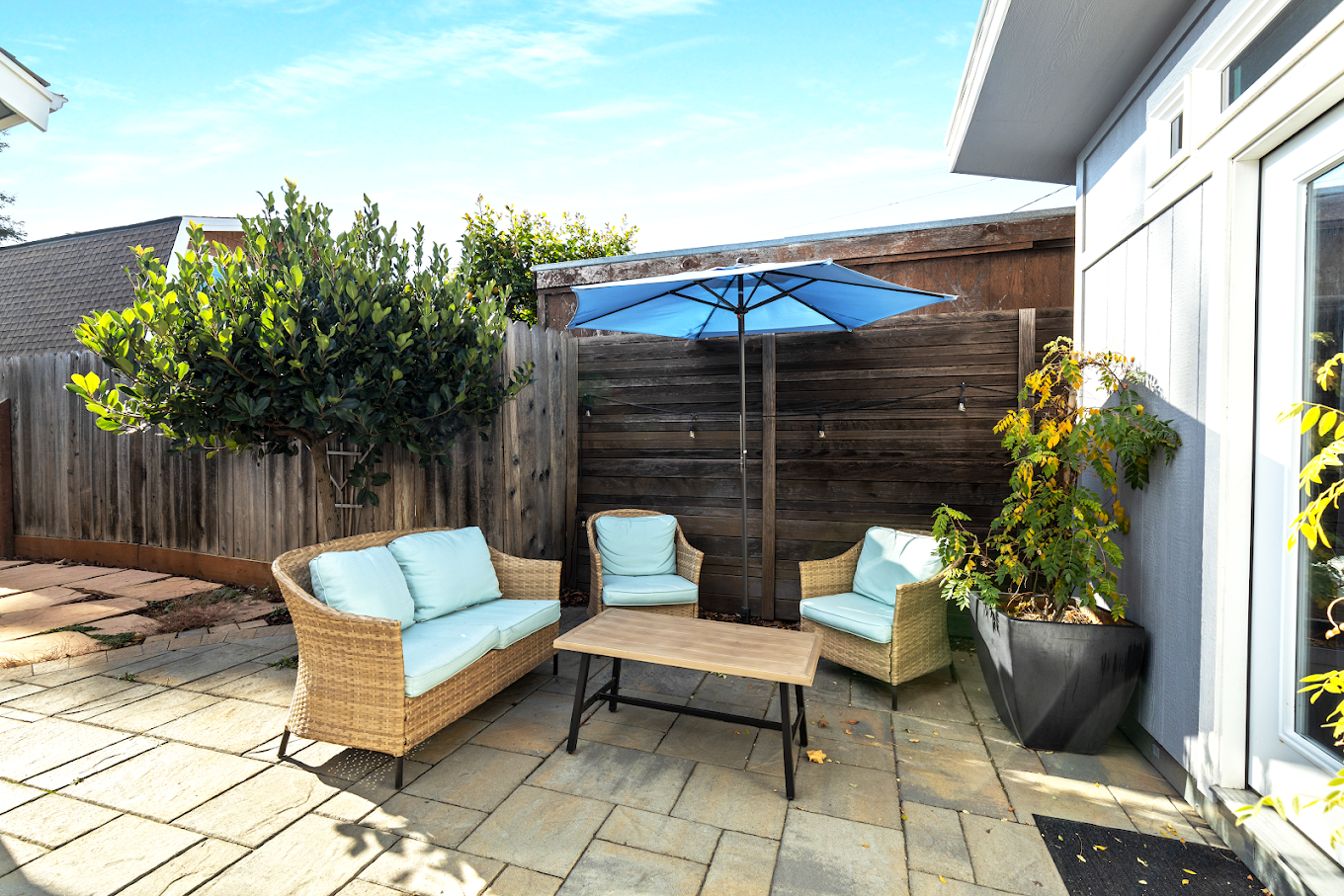 Patio seating with blue umbrella and chairs