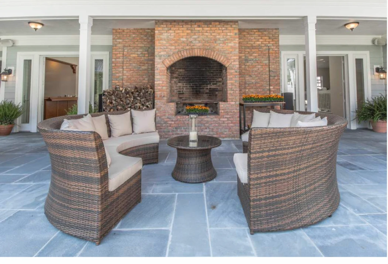 Patio with wicker chairs and brick fireplace