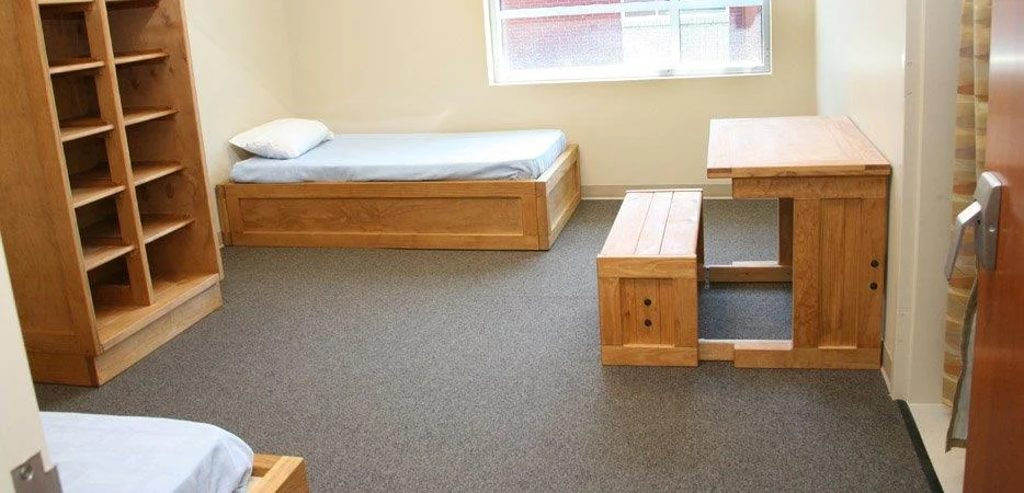 Shared bedroom with wooden beds and study desks