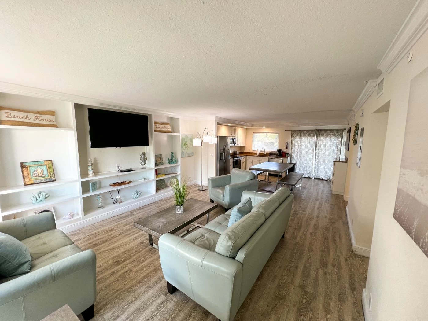 Open-concept community lounge with seating, dining table, and shared kitchen space