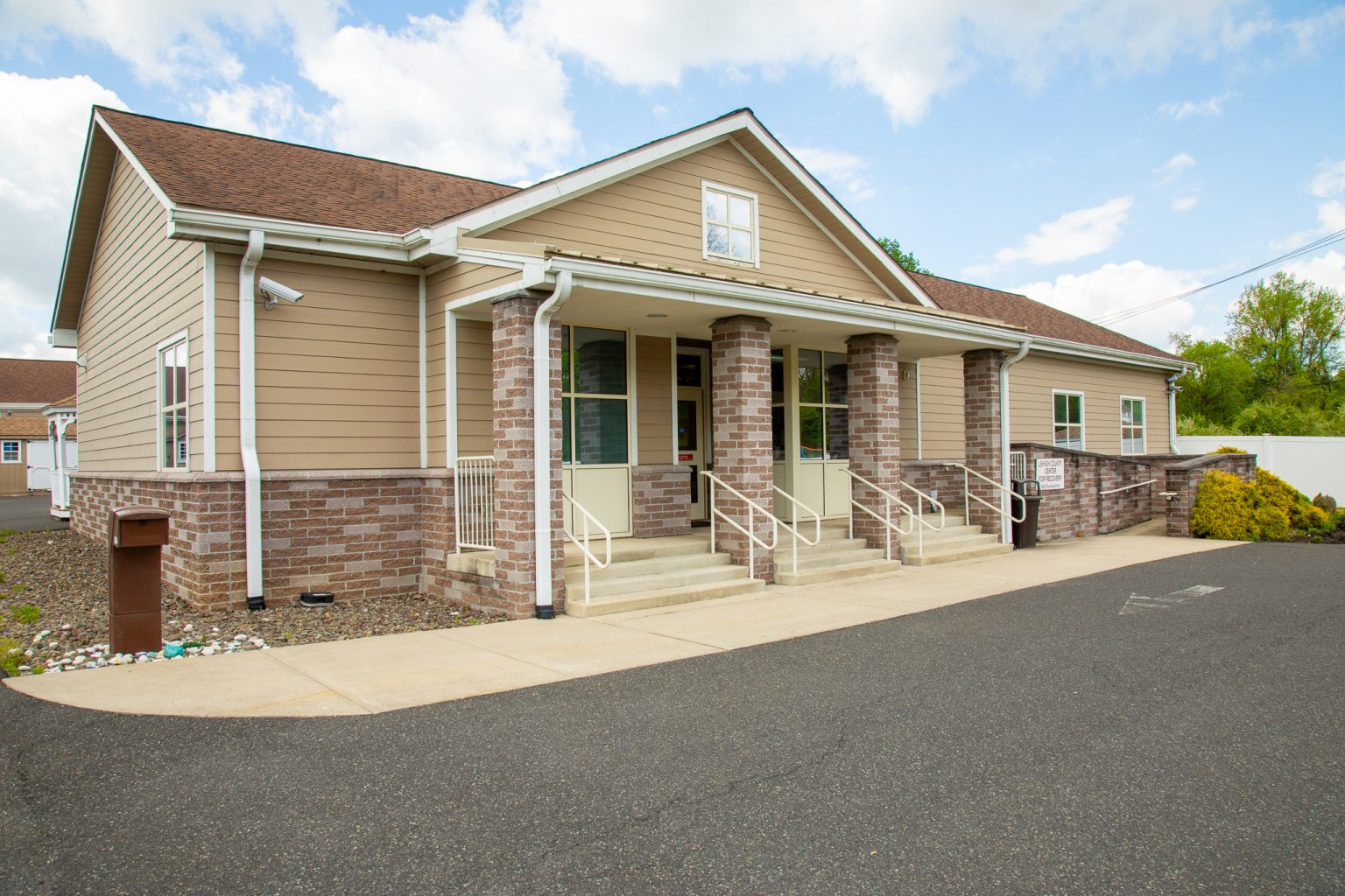 Rehab facility entrance with brick pillars and ramps