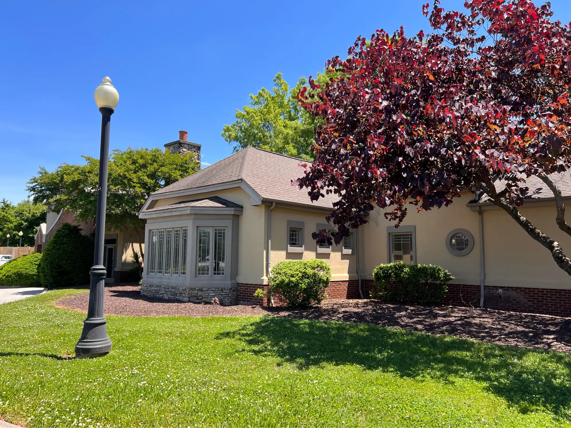 Building exterior with lawn, trees, and walkway