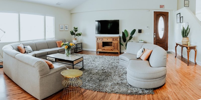 A bright, spacious living room with a cozy sectional sofa, stylish decor, and plenty of natural light, perfect for relaxation and comfort.