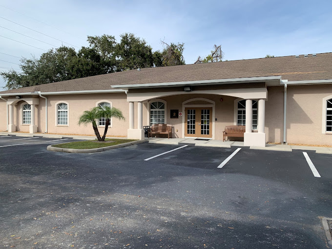 Beige building with white columns and bench seating