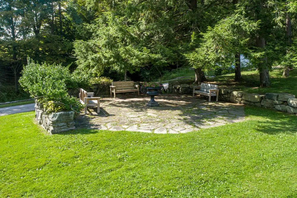 Garden patio with benches surrounded by mature trees