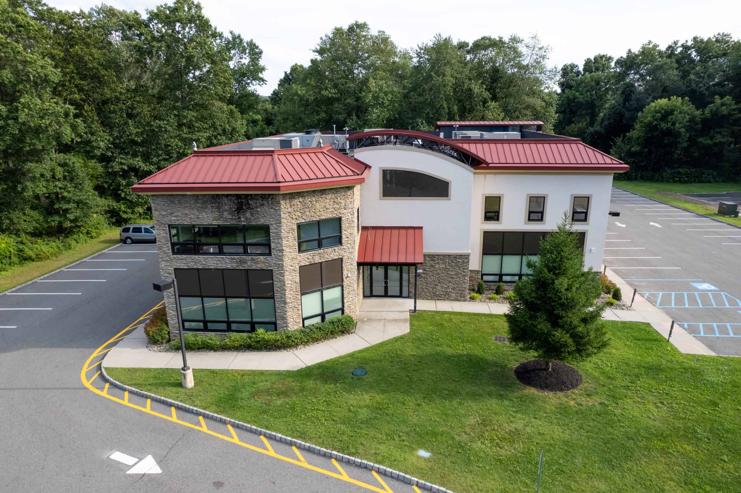 Modern rehab building with red roof and ample parking