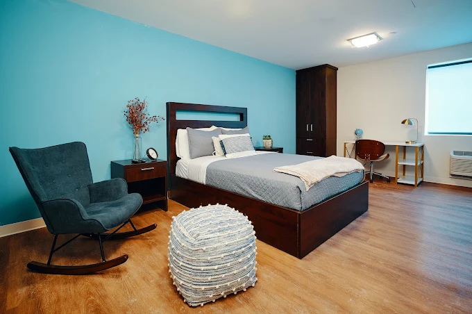 Private bedroom with queen bed, desk, and rocking chair