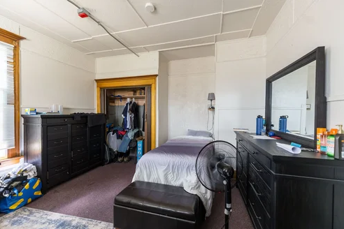 Simple bedroom with single bed, dresser, and closet