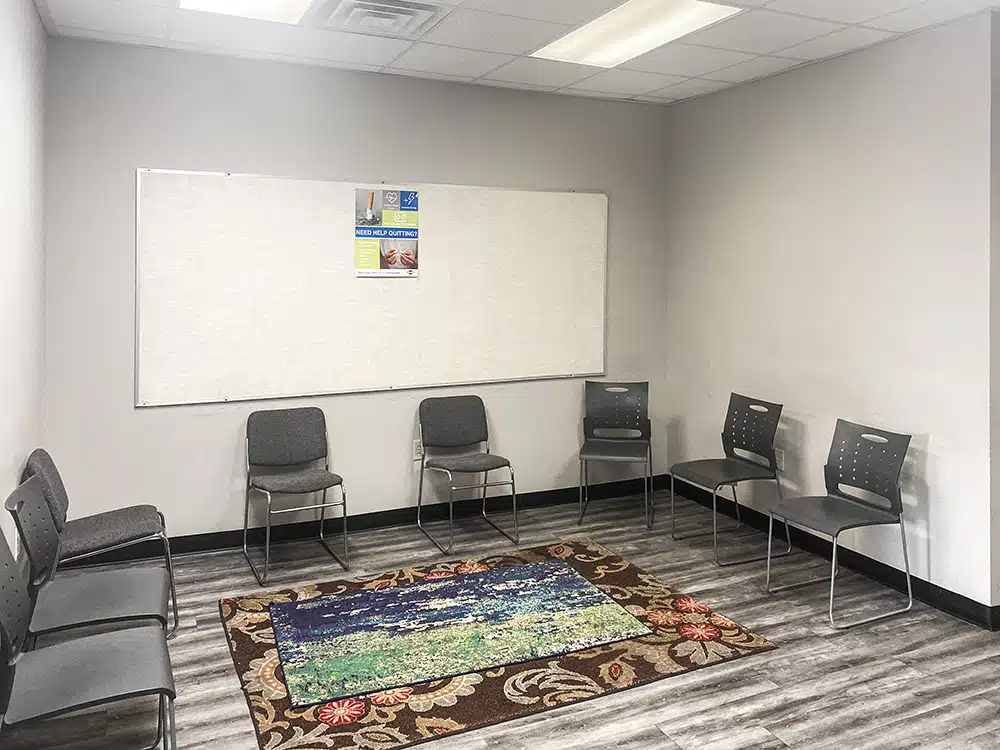 Group room with chairs, whiteboard, and patterned rug