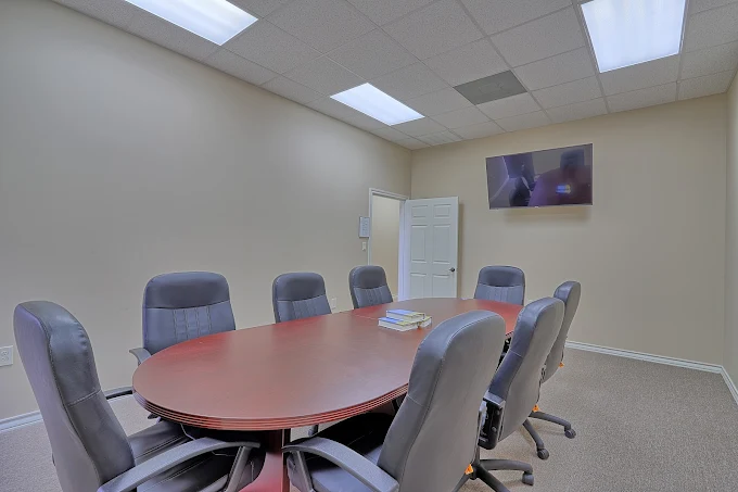 Conference room with oval table and gray chairs