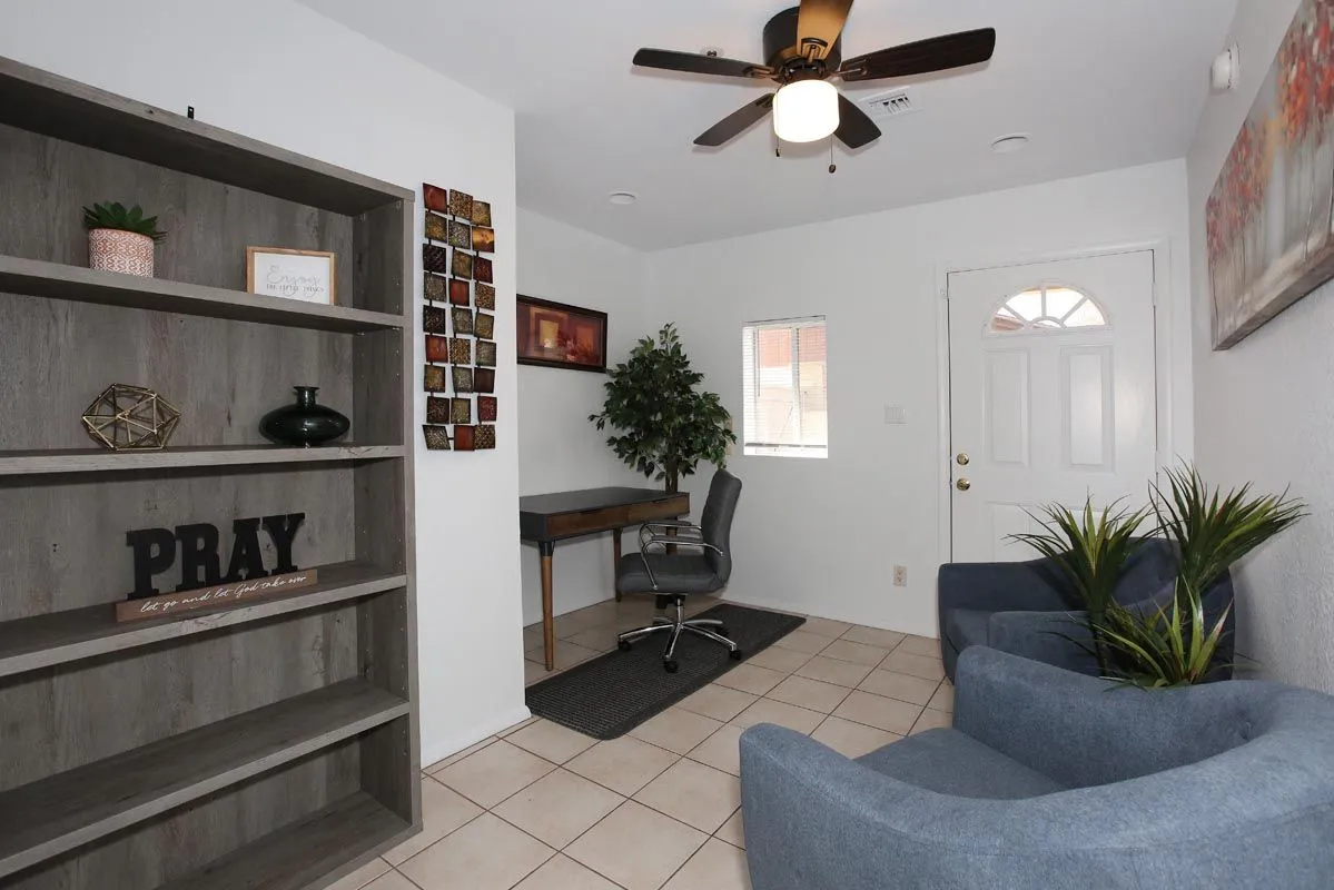 Entry lobby with seating, desk and shelving at Sanctuary Sober Living Rose Garden