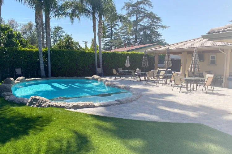Pool with patio seating and palm trees