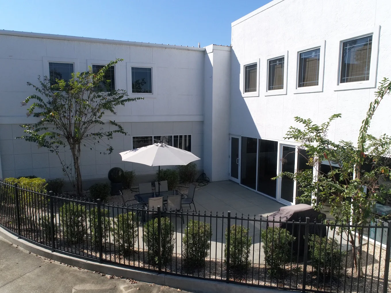 Landscaped courtyard with patio seating and large umbrella