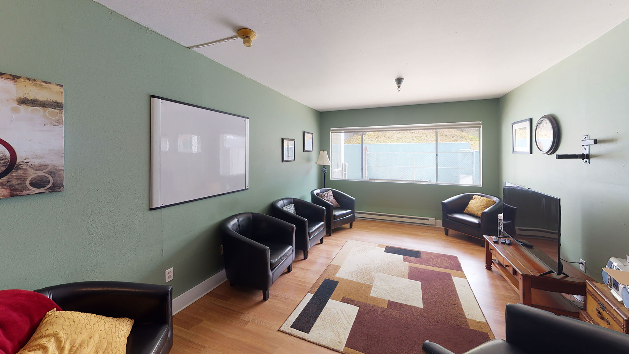 Lounge with armchairs, flat-screen TV, and rug
