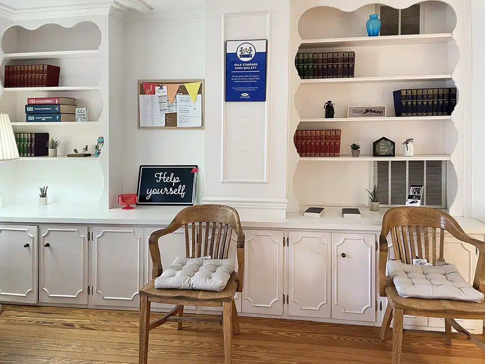 Seating area with wooden chairs and built-in shelves with books