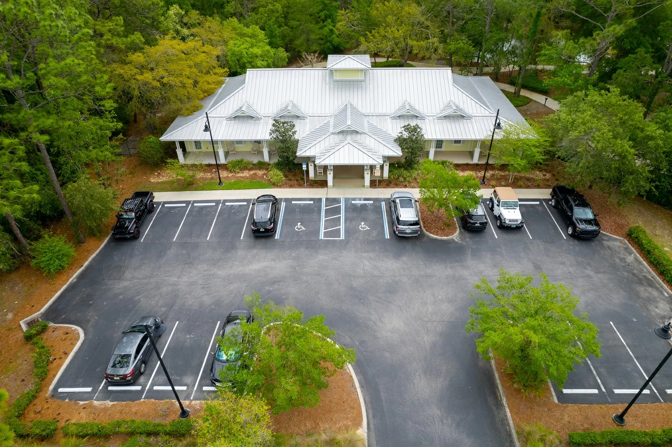 Overhead view of treatment center building surrounded by trees with parking lot and accessible parking spaces
