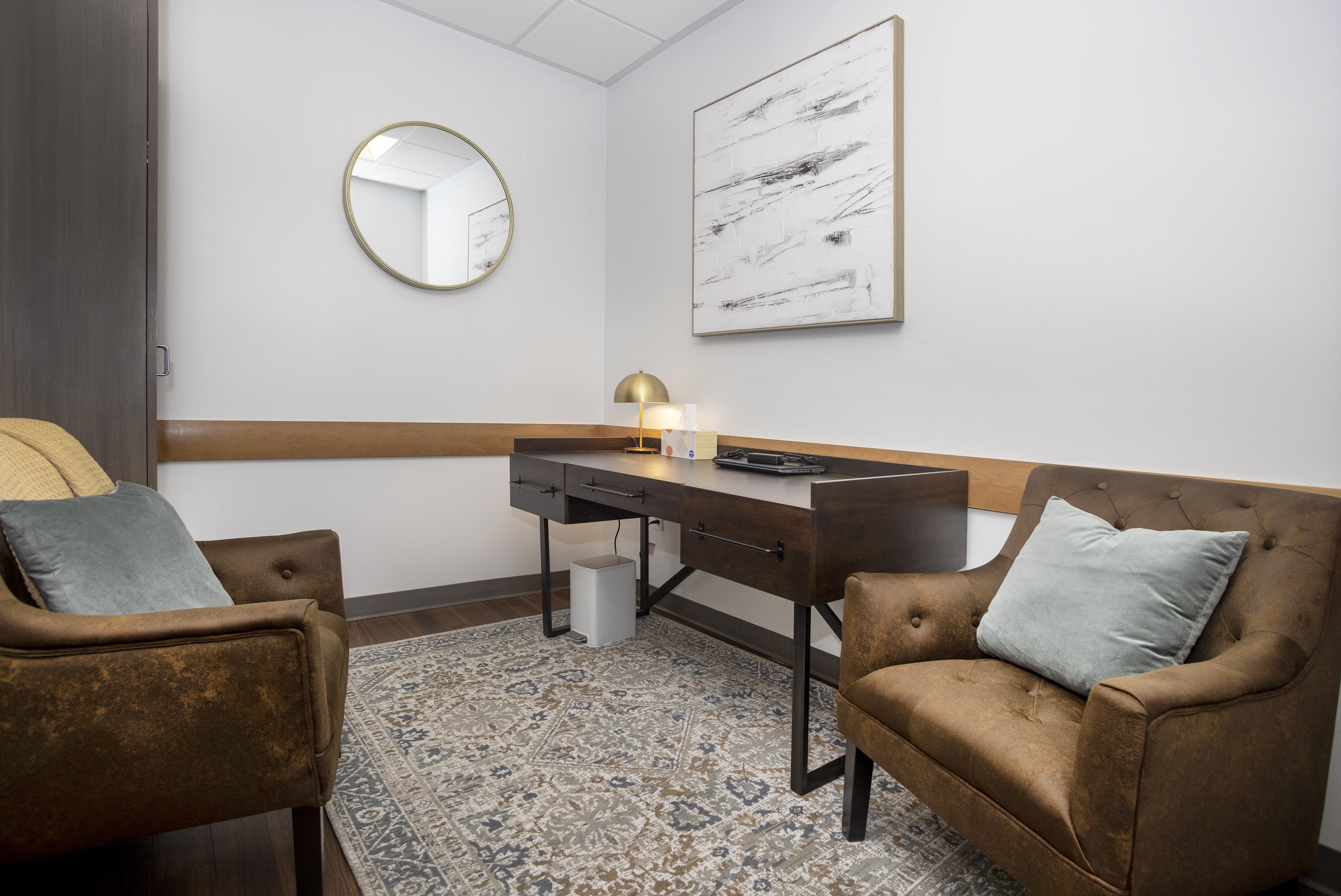 Office space with two arm chairs and a desk.