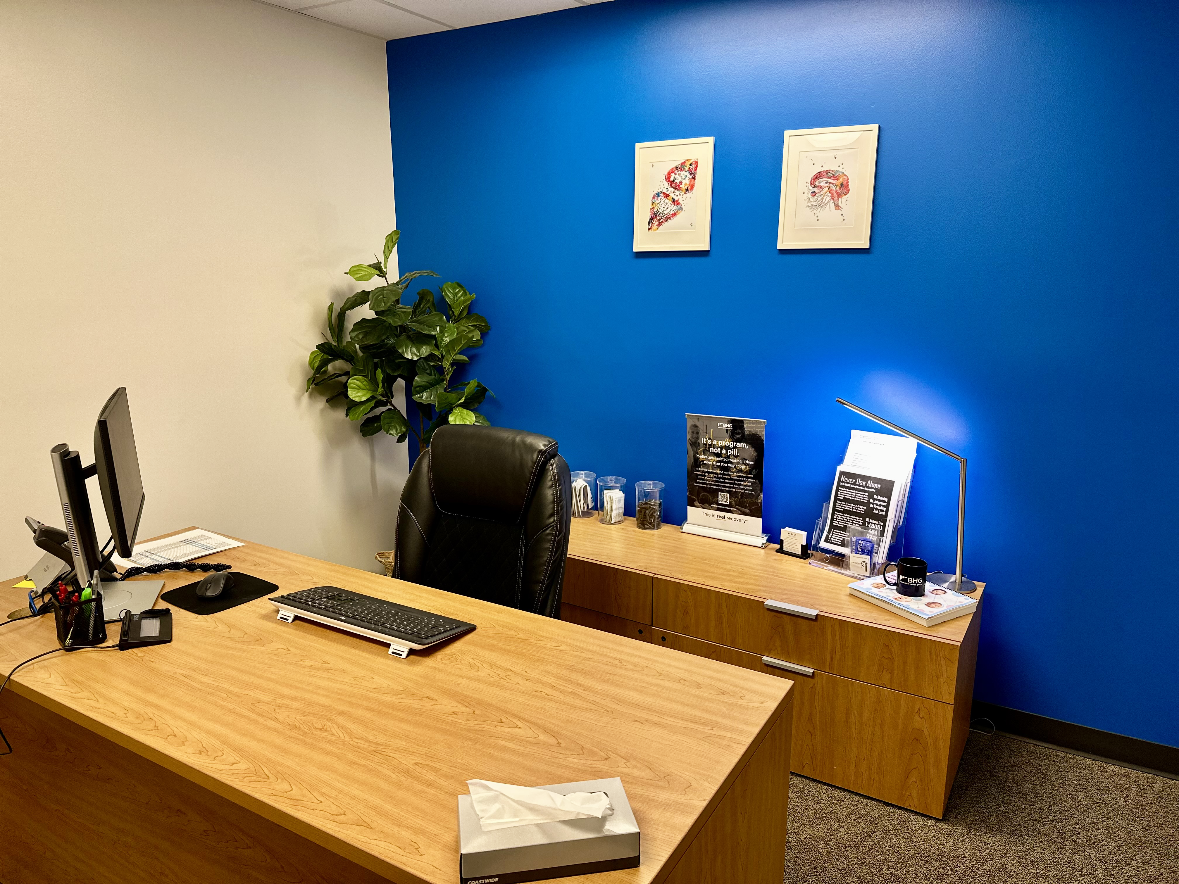Private office with desk, seating, and wall artwork