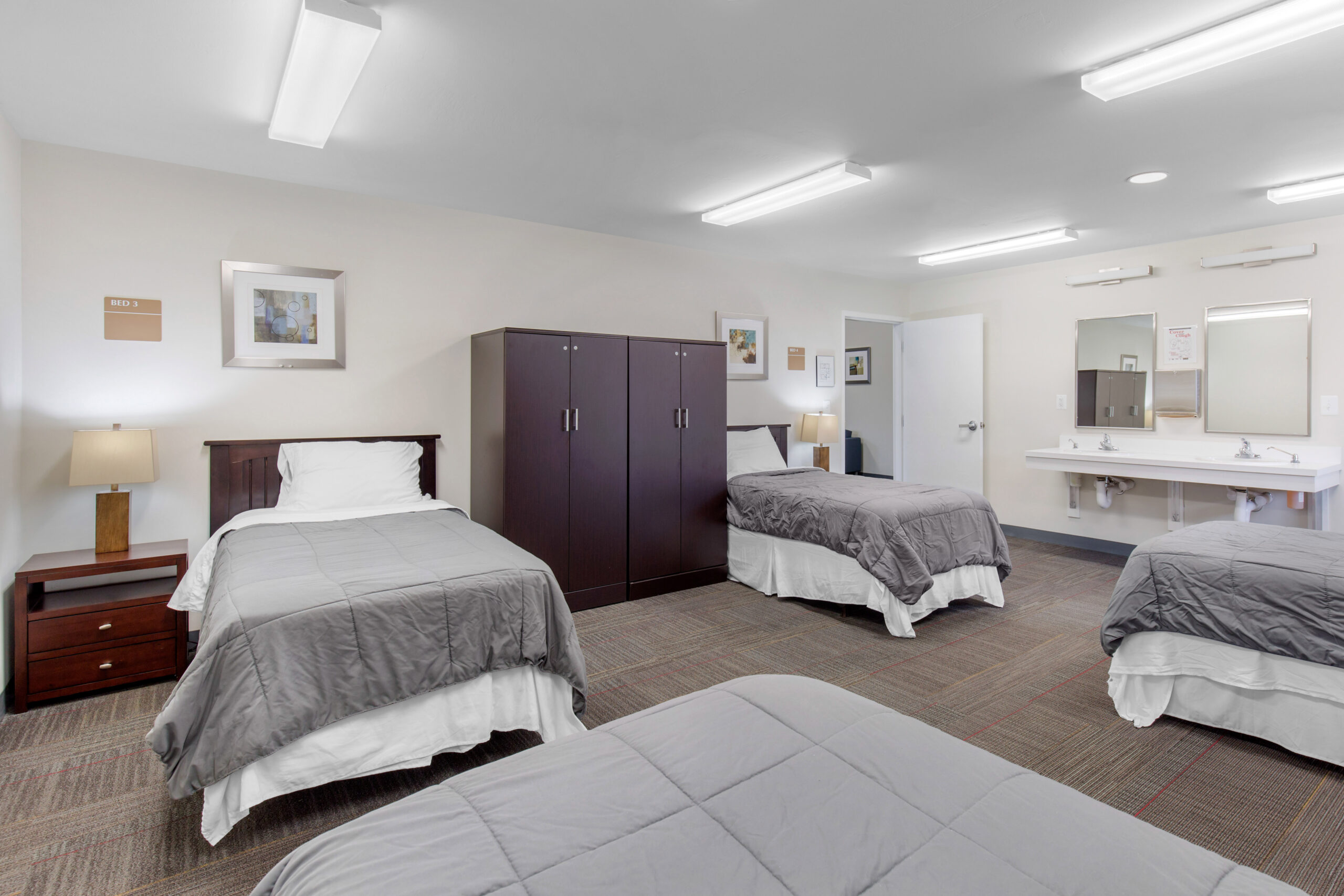 Shared bedroom with four twin beds and gray bedding