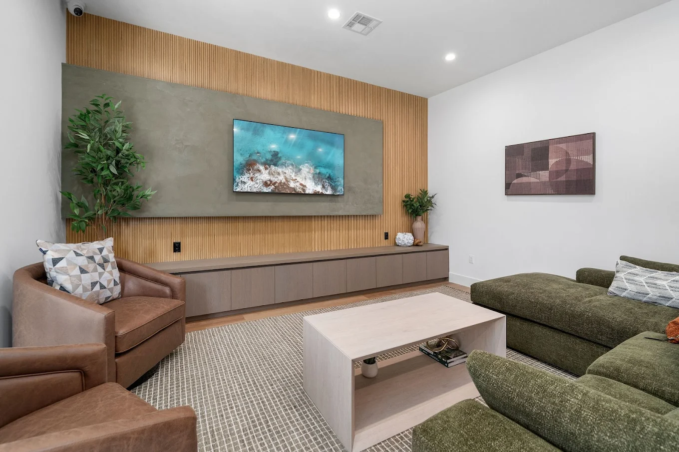 Living area with large TV, couch, and accent chairs