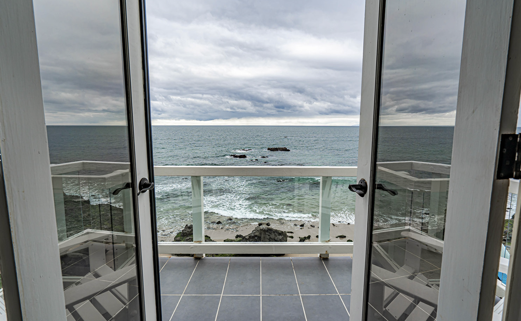 Balcony view of ocean and rocky shoreline