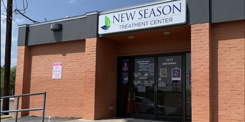 The entrance of New Season Treatment Center, a brick building with a clear sign above the door, creating a professional and welcoming atmosphere.