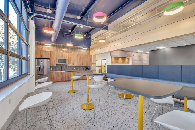 Kitchen and cafe area with colorful lights and modern stools.