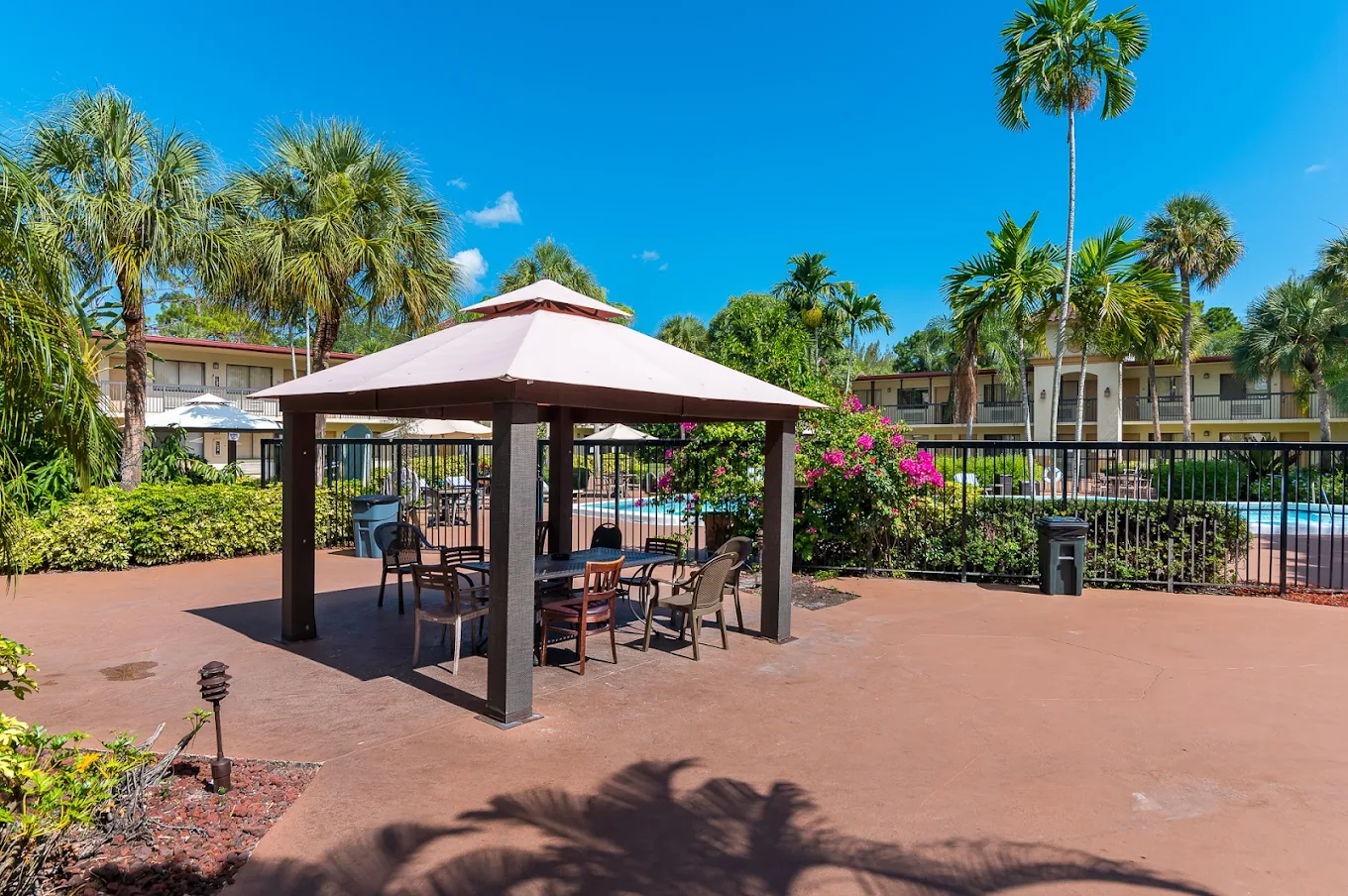 Shaded outdoor gazebo with seating near the pool.