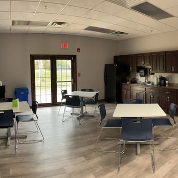Breakroom with tables, chairs, and full kitchen area