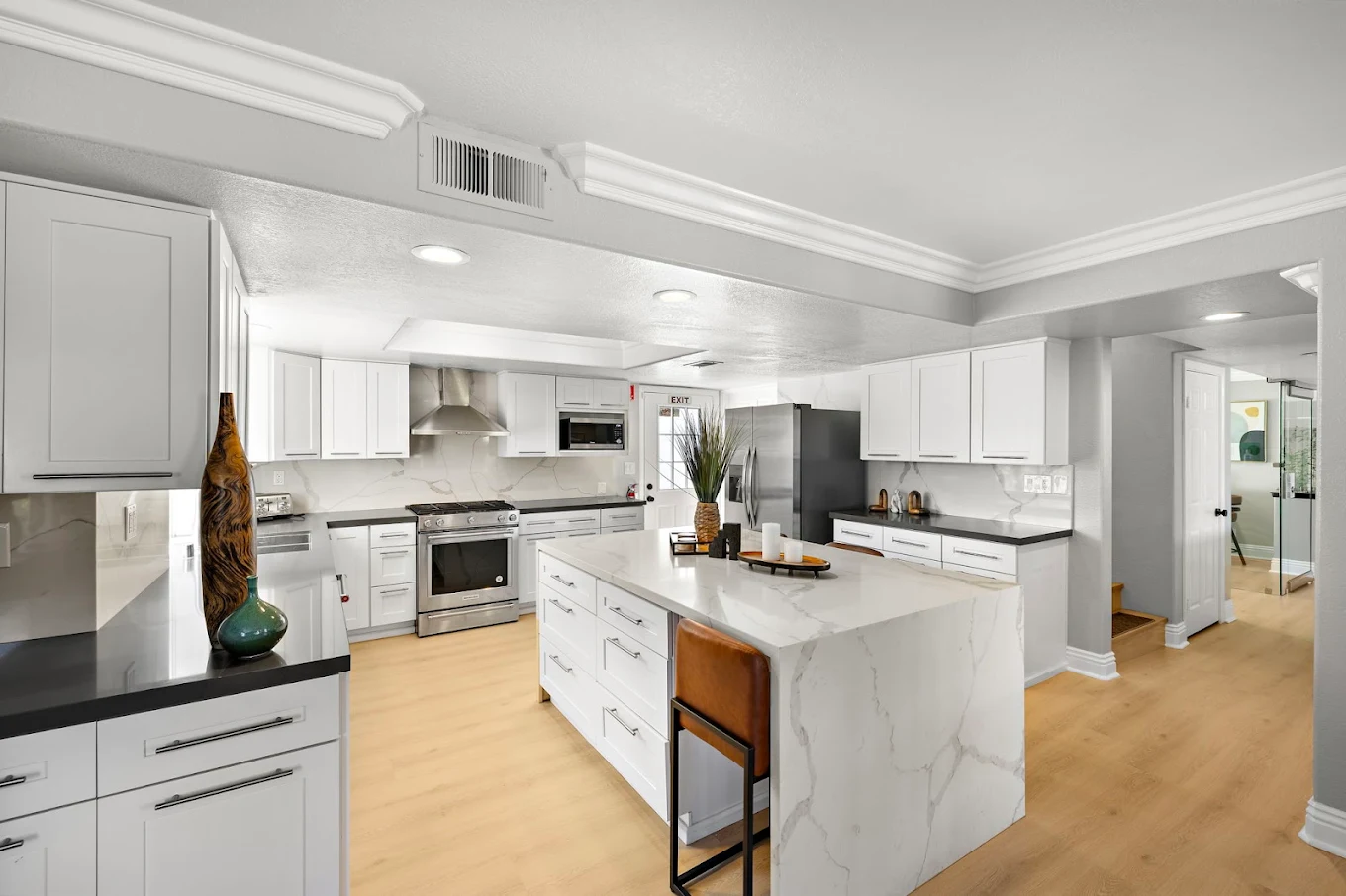 Modern white kitchen with marble island and stainless appliances