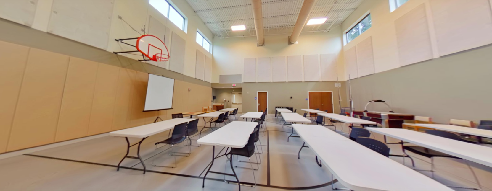 Indoor gymnasium with tables for group activities