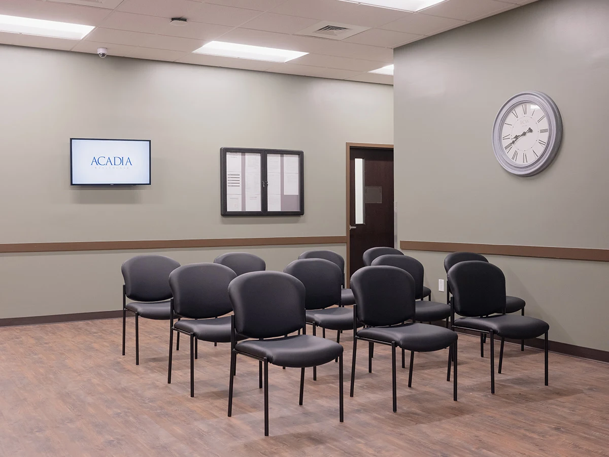 Waiting room with chairs facing TV and wall clock