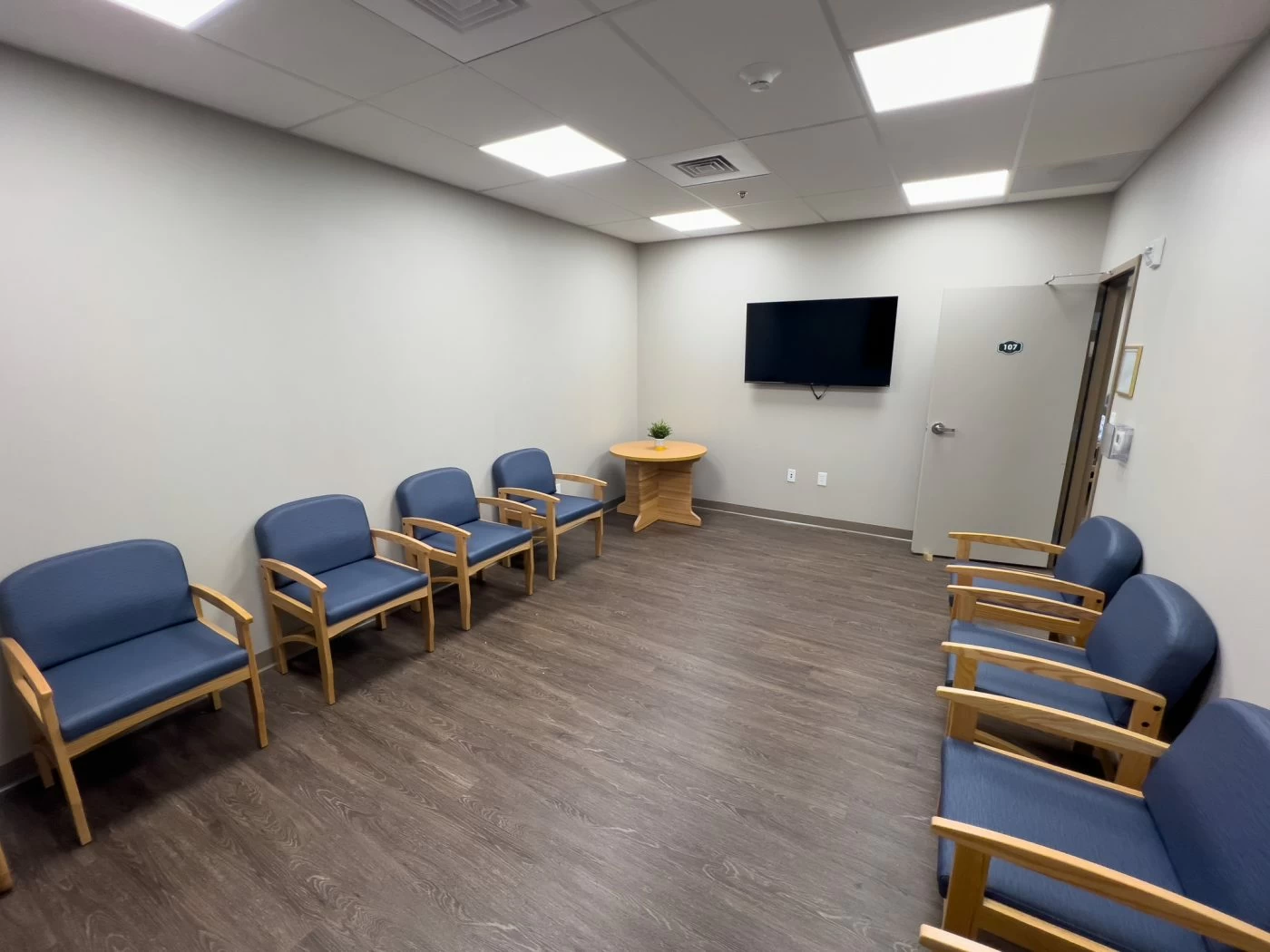 Quiet waiting room with chairs and wall-mounted television inside recovery center