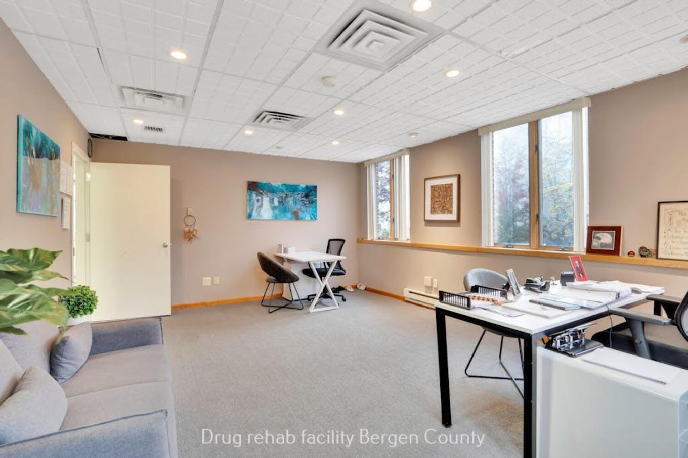 Therapy room with a couch, chairs and desks.