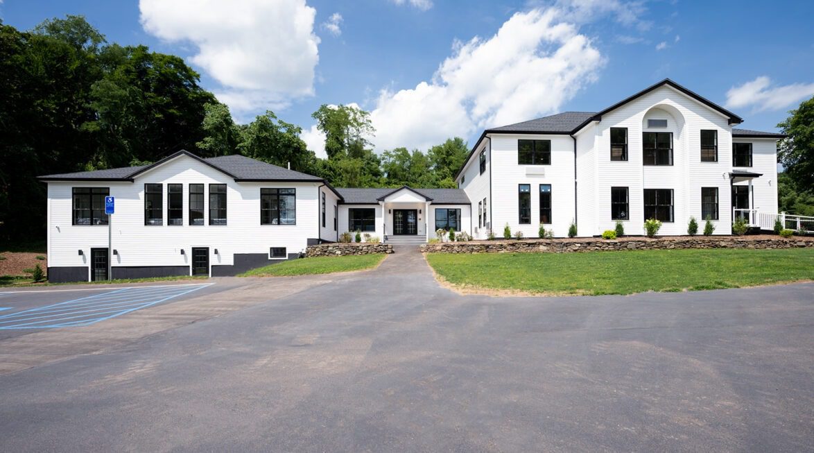 Exterior view of Paramount Wellness Retreat surrounded by landscaped grounds and wooded surroundings