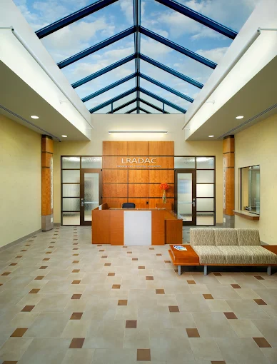 Bright lobby with skylight ceiling, reception desk, and sofa