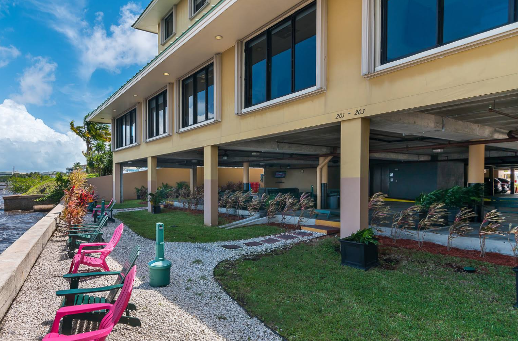 Outdoor seating area with colorful chairs by landscaped garden