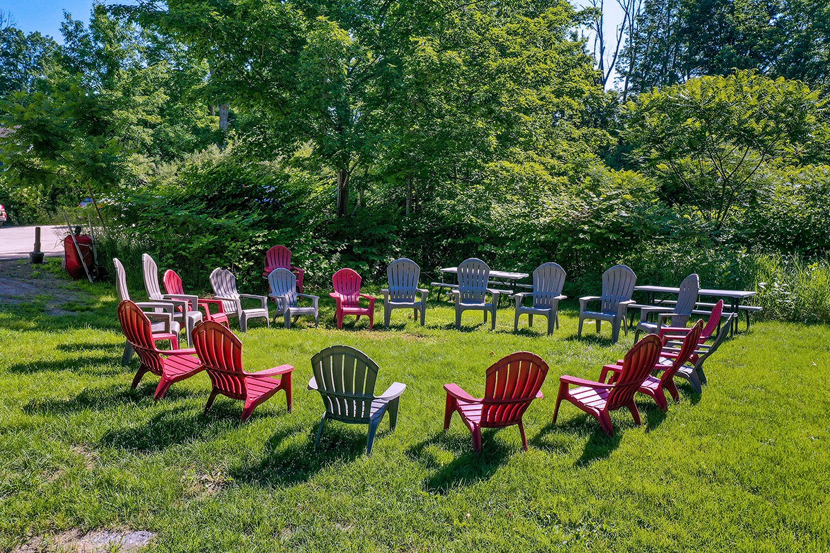 Circle of red and gray chairs on green grass