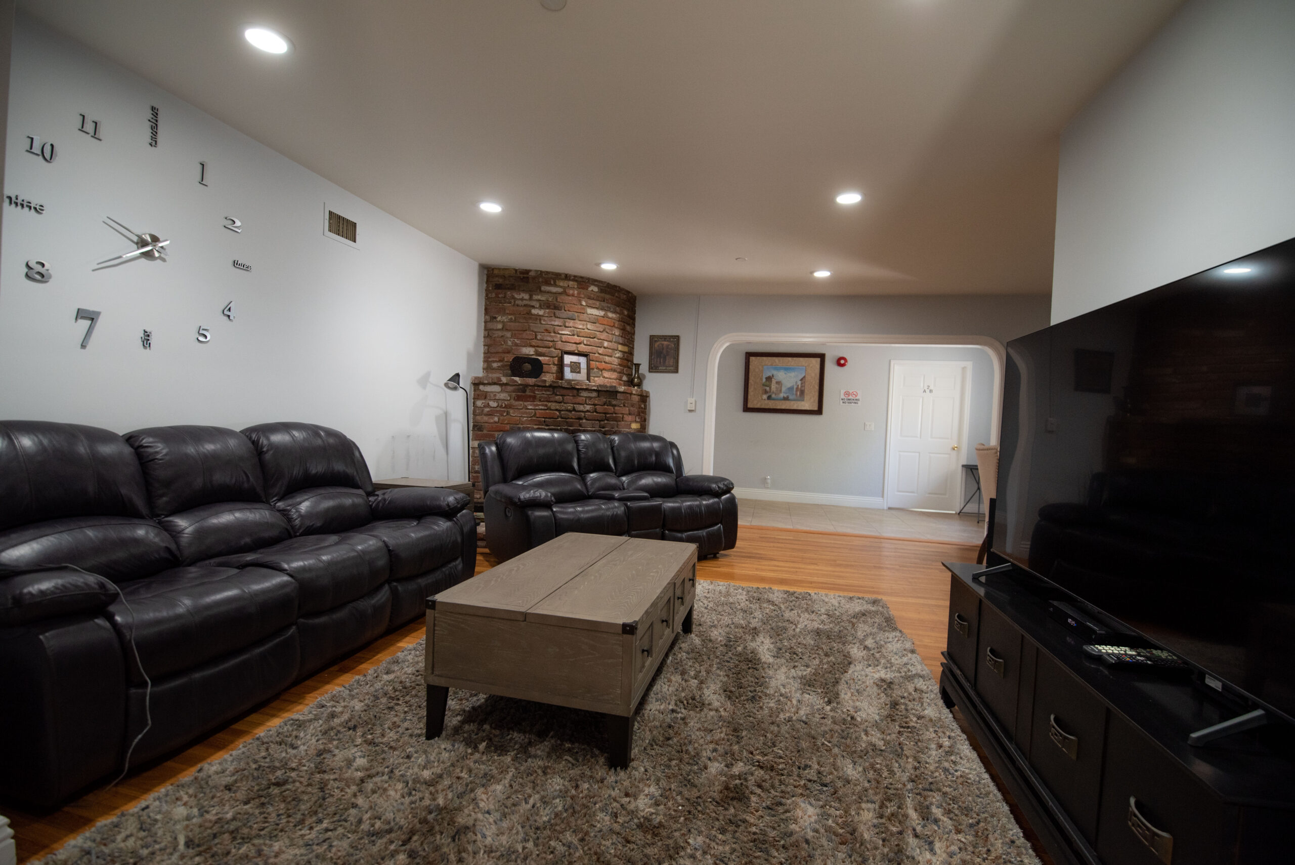 Living area with sofas, coffee table, and large TV