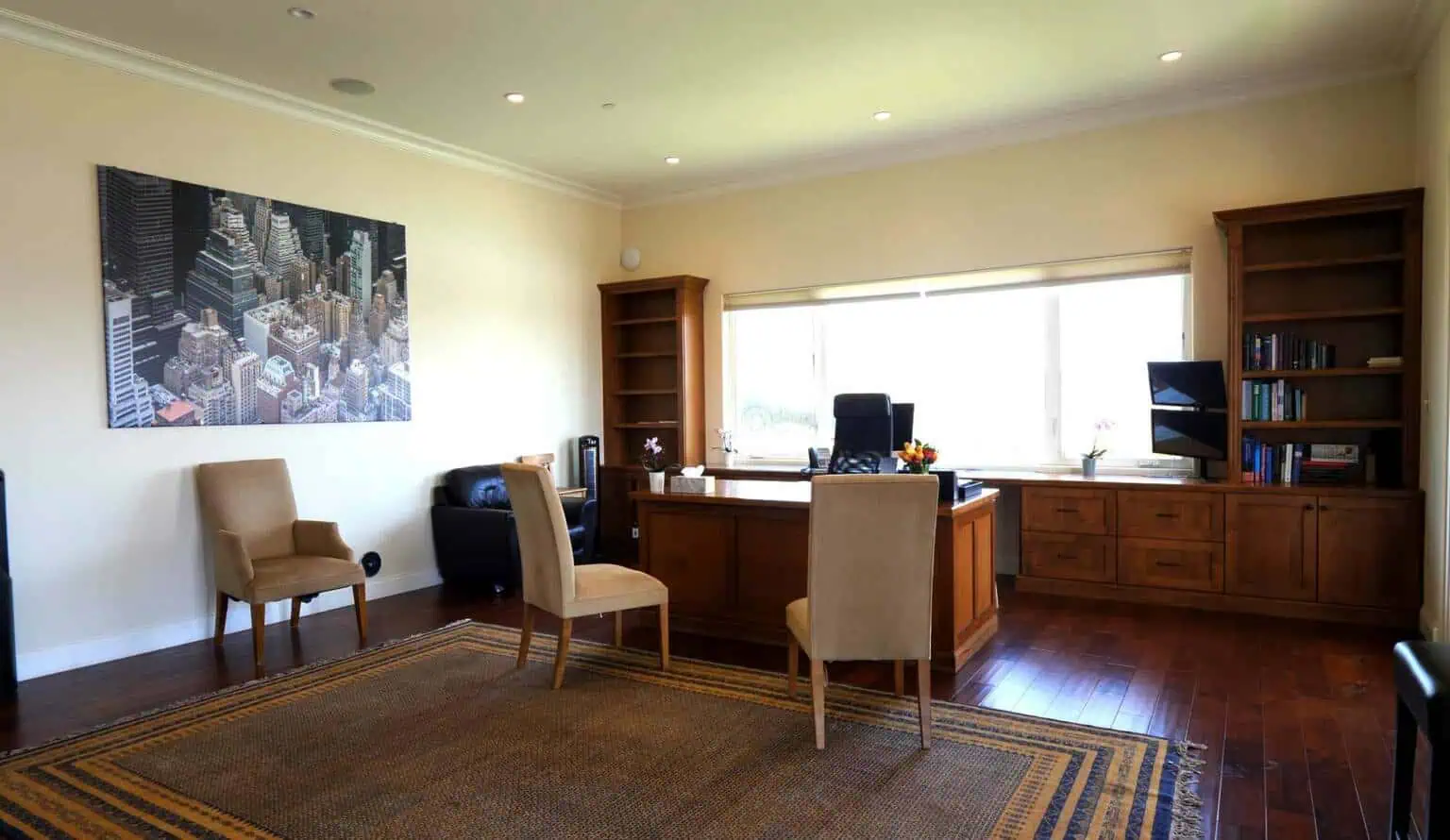 Office with desk, computer, bookshelves, and large window