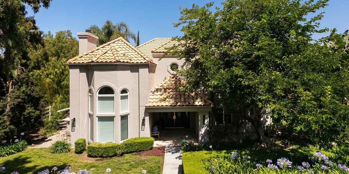 Large residential treatment home surrounded by trees and landscaping
