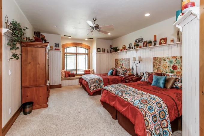 Colorful twin beds and bay seat in cheerful bedroom