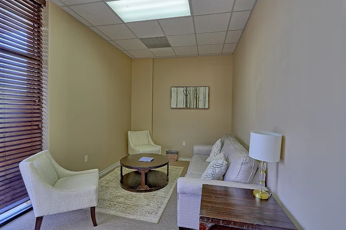 Cozy counseling room with sofa, chairs, and lamp